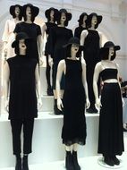 a group of manikins in black dresses