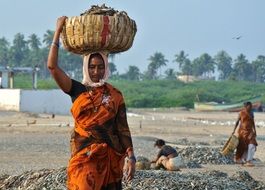 indian woman on her head with a basket full of fish