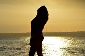 womans silhouette near the ocean
