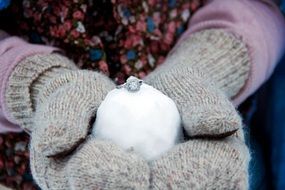 wedding ring on the snow in the hands of a girl