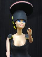 barbie doll in a dark dress and hat