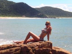 Woman relaxing on a rocky coast