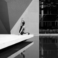 man in yoga pose sits on the edge of the roof