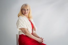 elegant woman in a red dress with a white cape