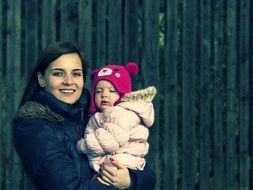 girl with baby near green wall