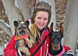 photo of a girl with a doberman and yorkshire terrier
