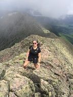 girl in a black t-shirt and shorts on top of a mountain