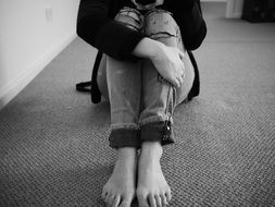 woman in ripped jeans in black and white image