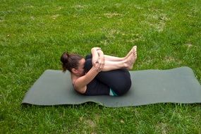 girl doing yoga on green grass