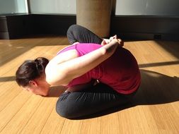 girl in a yoga pose on the floor in the hall