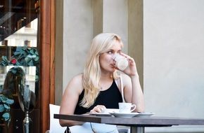 blonde woman drinks cappuccino