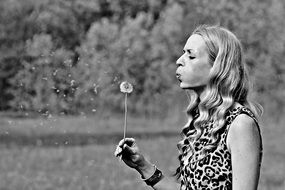 woman with dandelion in black and white background