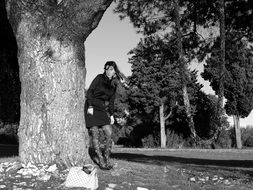 black white photo of a girl near a tree