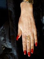 female hand with long red painted nails