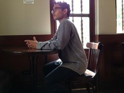 young man sitting on a chair at the table