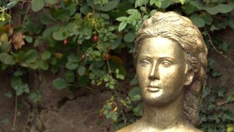 gilded bust of a woman in the park