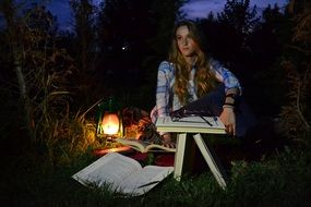 young woman with books in the darkness