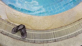 black slippers on the edge of the pool