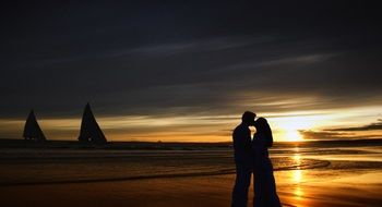 couple in love kisses at sunset