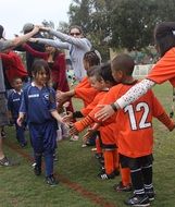 shaking hands of two kids soccer teams