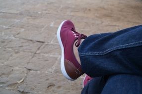 burgundy sneakers on the legs of the girl