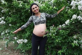 woman expecting a baby posing in the garden