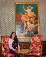 woman with long hair sitting on the antique furniture