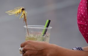 plastic cup with Alcohol Drink in female hand