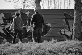 people near the fence in black and white background
