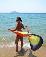 girl in a bathing suit with a colorful pareo on the beach