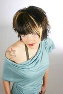 portrait of a young woman with tattoo on shoulder