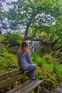 girl sits with her back on the edge of the bench