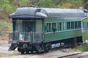 old Green passenger car on rural Railroad