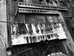 black and white photo of old keys hanging on the facade of a building