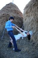 playful couple on the haystack background