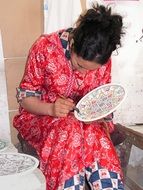 woman paints a plate