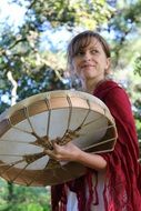 woman playing drum among the plants