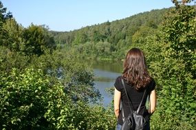 Girl looking at lake in a forest