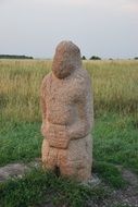 stone statue of a woman among the grass