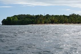 distant view of people resting on beach of caribbean island