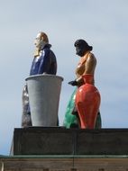 sculptures of white man and immigrant woman