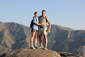 happy couple on top of rock