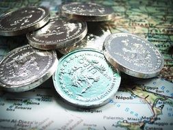 coins on a pile and map on a table