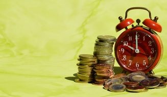 pennies near the alarm clock on a green background