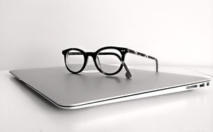 glasses on closed Macbook Laptop Computer