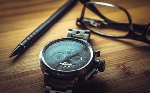 clock pen and glasses on the table