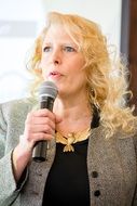 Speaker, adult caucasian woman with microphone