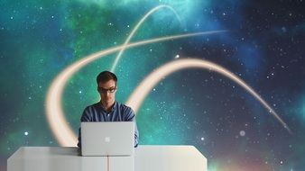 businessman sits at table with laptop