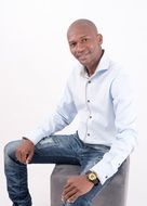 smiling dark skin man sits in studio