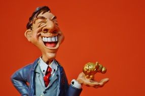 figurine of a businessman with a gold figure in his hand
